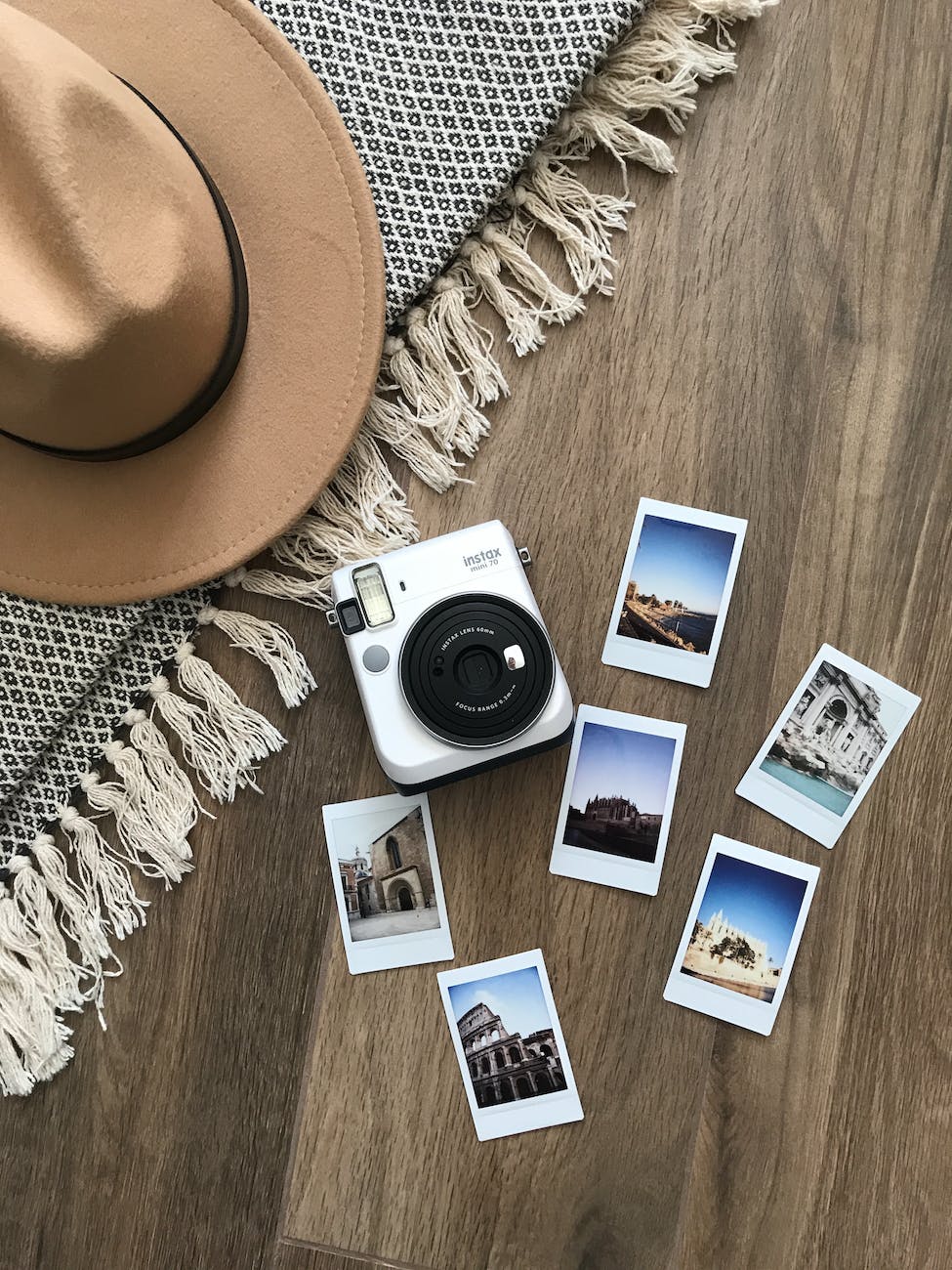 instant photos and camera on wooden floor with concept of travel